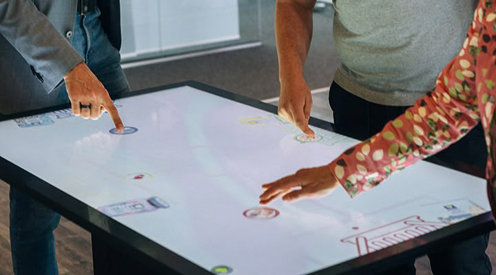 Multitouch table: several people using interactive content at the same time