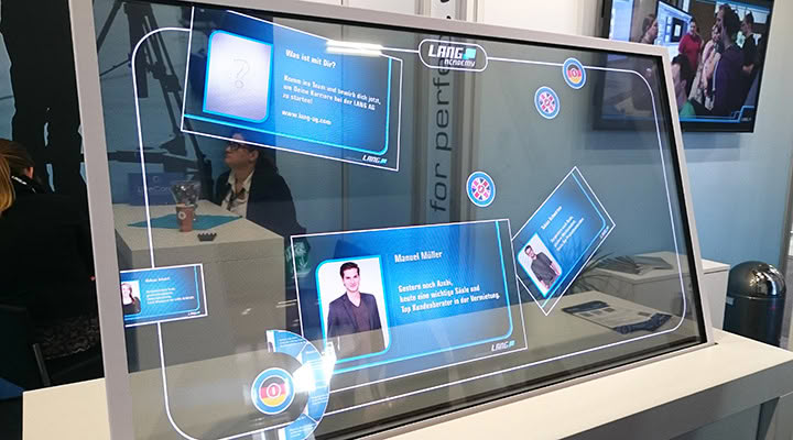 Semi-transparent touchscreen with interactive content at a trade show booth